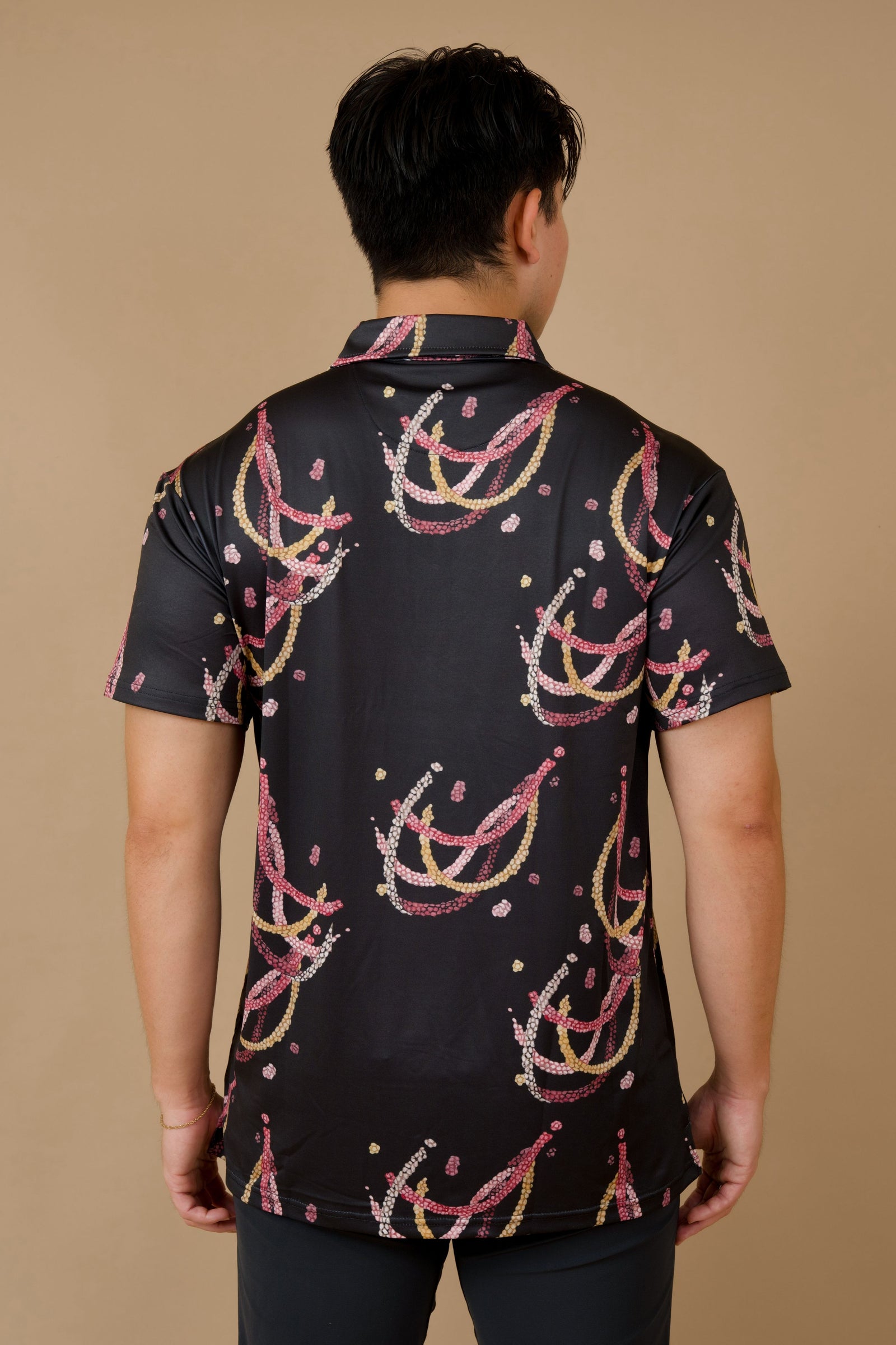 Men's Holoholo Polo Shirt in Black Lei Kahelelani - Back View | Kahulaleʻa