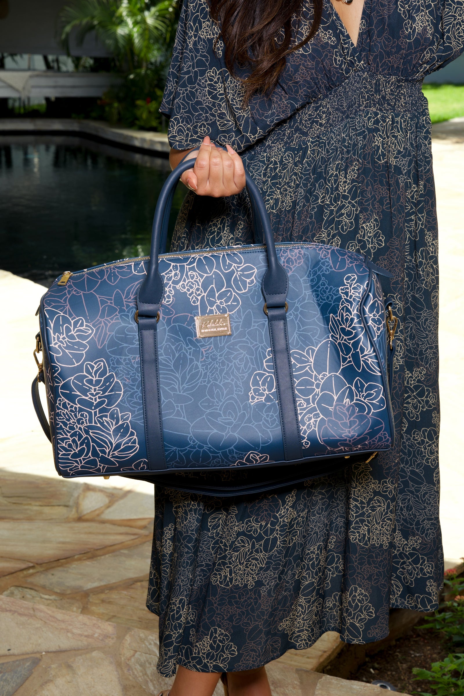 Close up of model holding a Duffel Bag in the Midnight Liko print by Kahulaleʻa