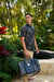Male model holding a Duffel Bag in the Midnight Liko print by Kahulaleʻa